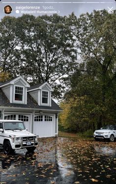 two trucks parked in front of a house on a rainy day with leaves all over the ground