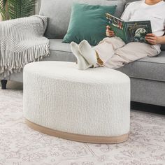 a woman sitting on a couch reading a book