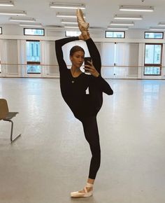 a woman is doing ballet in an empty room