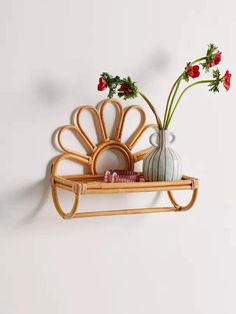 a vase with flowers in it sitting on a shelf next to a wall mounted rack