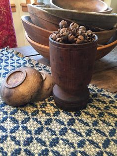 a wooden bowl filled with nuts sitting on top of a blue and white table cloth