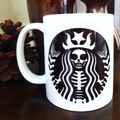 a starbucks coffee mug with a skull on it