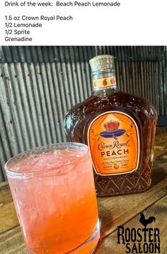 a bottle of booze next to a glass filled with orange liquid on top of a wooden table