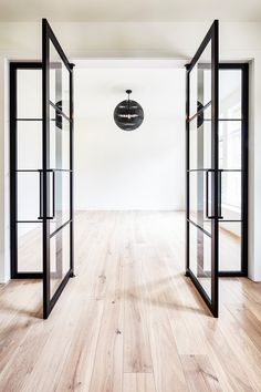 an empty room with glass doors and wooden floors