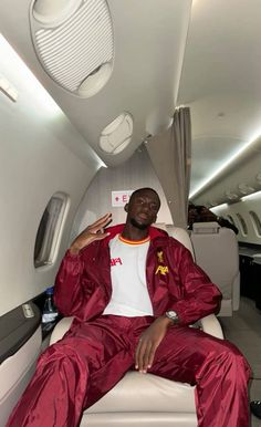 a man in red and white pajamas sitting on an airplane