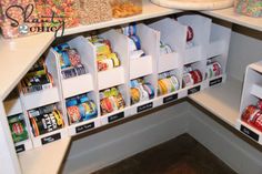 an organized pantry with cereals, cereal bars and other snacks in bins on the shelves