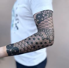 a man's arm with an intricate tattoo design on the arm and shoulder,