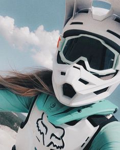 a woman wearing a helmet and goggles standing in the snow