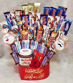 a red bucket filled with assorted chocolates and candy bar wrappers in front of a white background