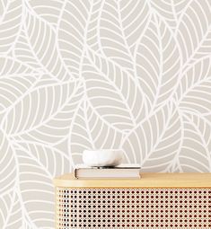 a speaker sitting on top of a wooden cabinet in front of a wallpapered background