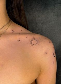 the back of a woman's shoulder with stars and moon tattoos on her chest