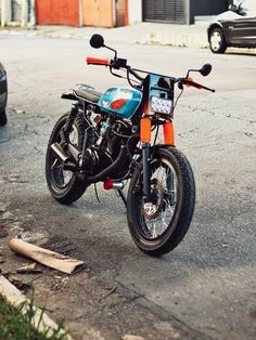 an orange and blue motorcycle parked on the street