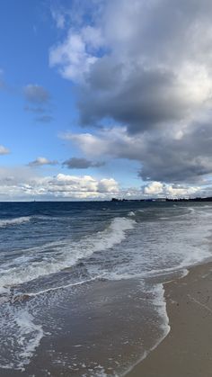 the beach is empty with waves coming in to shore