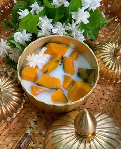 a bowl filled with fruit and yogurt next to flowers