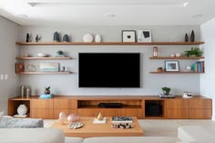 a flat screen tv sitting on top of a wooden entertainment center in a living room