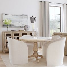 a living room with white furniture and curtains