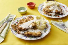 two plates filled with food on top of a yellow table cloth next to silverware