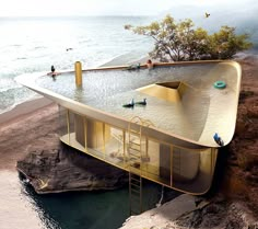 an unusual house built into the side of a cliff by the ocean with people swimming in it