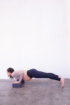 a woman is doing push ups on her stomach