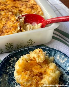 a casserole dish with mashed potatoes on a blue and white plate next to a red spoon