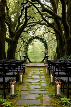 an outdoor ceremony set up in the middle of a forest with rows of chairs and lit candles