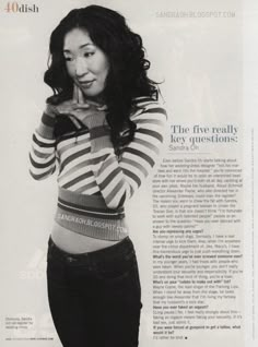 a woman in striped shirt posing with her hand on her chin and looking at the camera