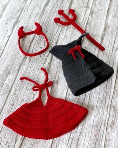 three crocheted items are laying on a wooden surface, one is red and the other is black