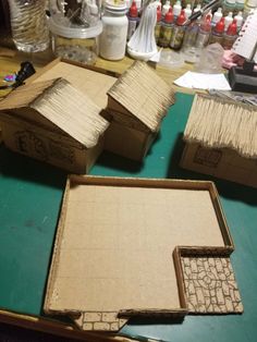 three cardboard houses sitting on top of a table