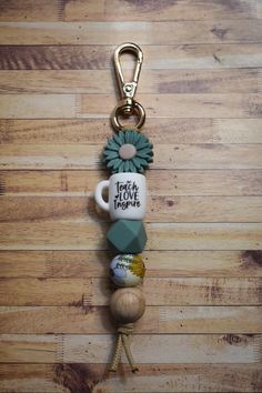 a keychain with a coffee mug on it and some beads attached to it