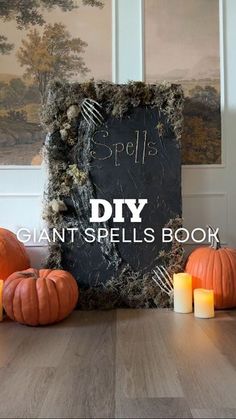 pumpkins and candles on a table with a sign that says diy giant spells book