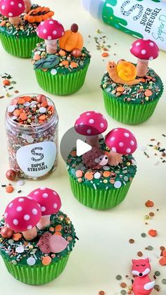 cupcakes decorated with mushrooms and sprinkles on top of a table