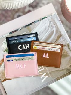 three credit cards sitting next to each other on top of a wooden table in front of a lamp