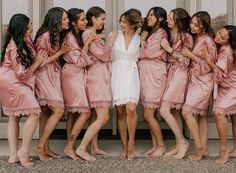 a group of women in pink robes standing next to each other with their arms around one another