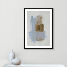 an abstract painting hangs on the wall next to a white vase with a flower in it