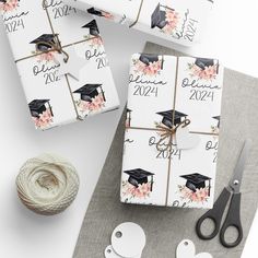 graduation gifts wrapped in white paper and tied with twine on top of a table