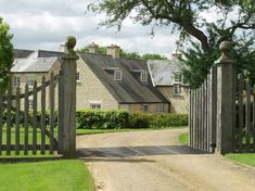 a gated driveway leading to a large house