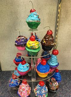 there are many cupcakes on the glass stand