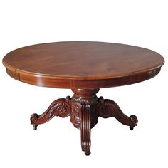 an oval wooden table with ornate carvings on the legs