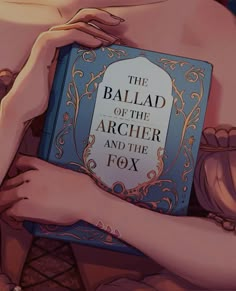 a close up of a person holding a book in their hands with the title'the ballad of the archer and the fox '