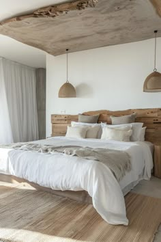 a large bed sitting in the middle of a bedroom next to two lamps hanging from the ceiling