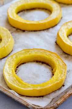 some yellow rings are sitting on a baking sheet and ready to go into the oven