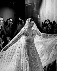 a black and white photo of a woman in a wedding dress