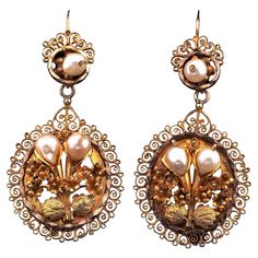 Georgian to Treasure Quite spectacular in design these antique drop earrings, 18 KT solid gold, hand crafted during the Georgian period , 1820 ca They are of amazing workmanship, the main panel is a large oval with a centre bunch of flower artwork, three-dimensionally created of gold and adorned with natural Pearls resembling two buds, framed by girandoles made of filigree work, same top feature with only one natural Pearl and Filigree background Surprisingly beautiful,witness of the unique Georgian artistry They are 50 x 24 mm. (h. x w.) with 6.4 grams gross weight They come to us in very good wearable condition keeping with age Rare find to treasure and wear proudly, not suggested for everyday, to handle with care Further Details Below Metal: 18 Kt yellow gold, tested Hallmarks: none/wor Georgian Jewelry, Flower Bunch, Flower Artwork, Gold Hand, Water Pearls, Natural Pearl, Bunch Of Flowers, Pearl Flower, Natural Pearls