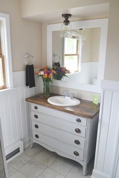 a bathroom with a sink and mirror next to a window on the wall in front of it