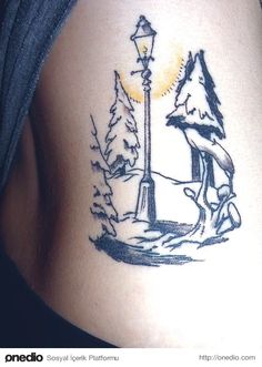 an image of a tattoo on the back of a woman's stomach with trees and a lamp post