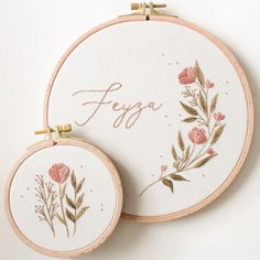 two embroidered hoops with flowers and the words feigo written on them are sitting next to each other