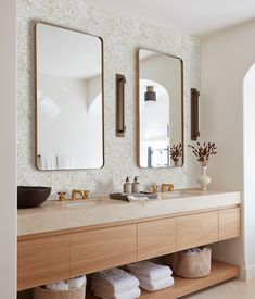 a bathroom with two sinks and three mirrors