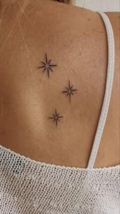 the back of a woman's neck with three stars on it