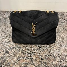 The Ysl Saint Laurent Medium Loulou Black Suede Gold Hardware Is In Used Condition. The Exterior Has Wear On The Sides Of The Flap And Back Of The Bag. The Magnetic Closer To The Flap Has Wear On Both Sides. The Underside Of The Bag Has Wear On The Bottom And Corners. The Interior Zipper Has Water Stains On It. Both The "Saint Laurent" Logos On The Interior Have Spots Where It Is Fading. It Has Stains And Discoloration On The Interior And Exterior. The Overall Condition Of The Bag Is A (B) No Dustbag Or Box Is Included. Bags Ysl, Ysl Saint Laurent, Yves Saint Laurent Bags, The Saint, Water Stains, Black Suede, Gold Hardware, Interior And Exterior, Yves Saint Laurent