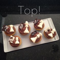 cupcakes with chocolate frosting and white icing are on a platter